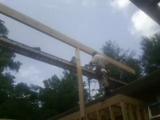 Carpenter setting a ridge beam over a new addition frame — Ice Dam Removal by Roofing Brothers in Kulpmont
