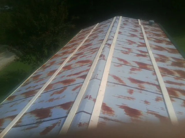 Rusted metal roof panels with new wood purlins before replacement — Storm Damage Roof Repair in Kulpmont by Roofing Brothers