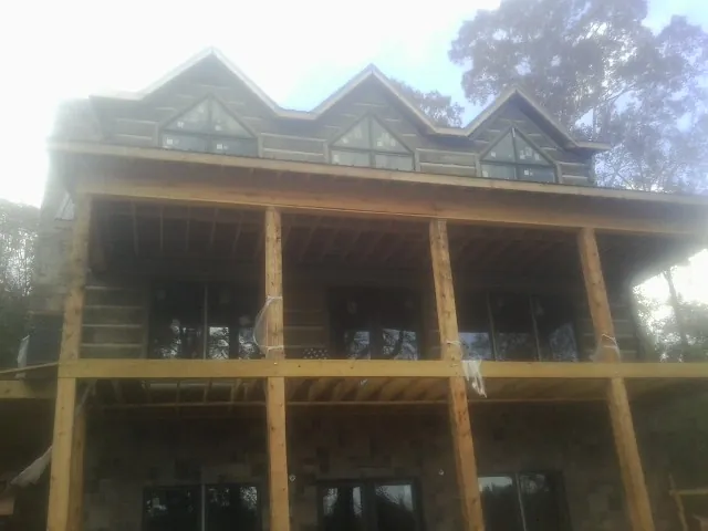Dormers and porch framing on a large log home under construction — Roof Coating work by our crew in Kulpmont
