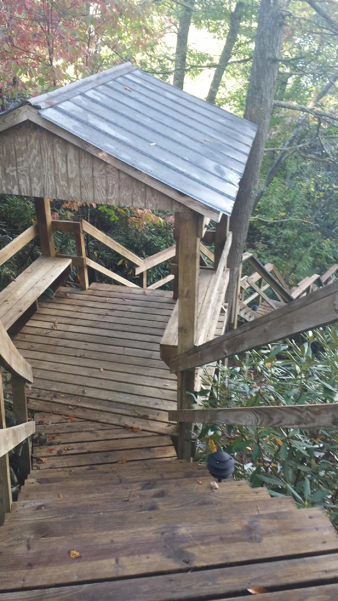 Metal roofed shelter over wooden steps on a wooded walkway — Skylight Repair & Installation work by our crew in Kulpmont